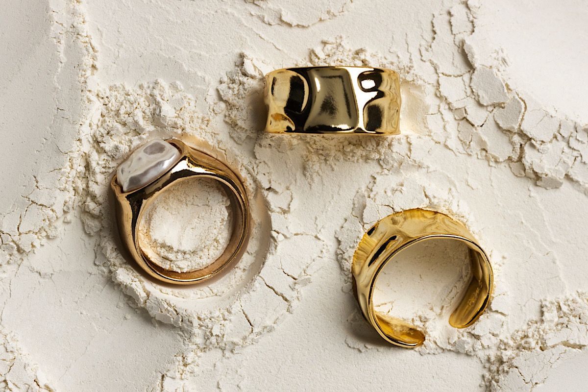 Vergoldete Ringe im Sand am Meer