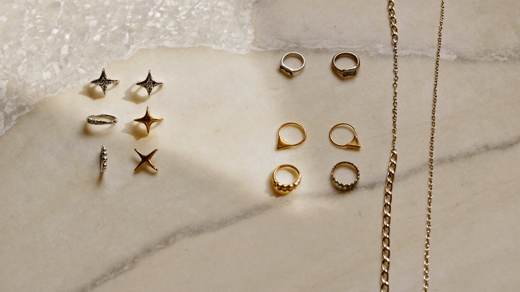 Edelstahl und Silber im Vergleich: silberfarbener und goldfarbener Schmuck auf Marmor